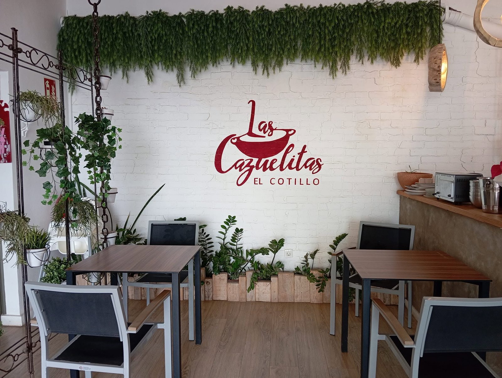 Interior de Las Cazuelitas con plantas tropicales y decoración rústica